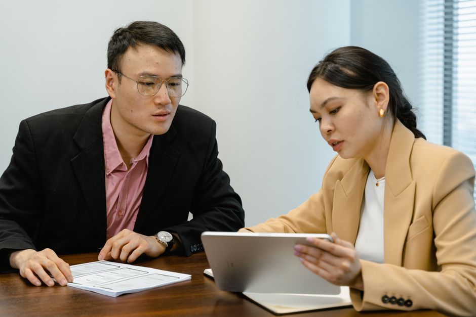 Business meeting with colleagues discussing ideas using a tablet.