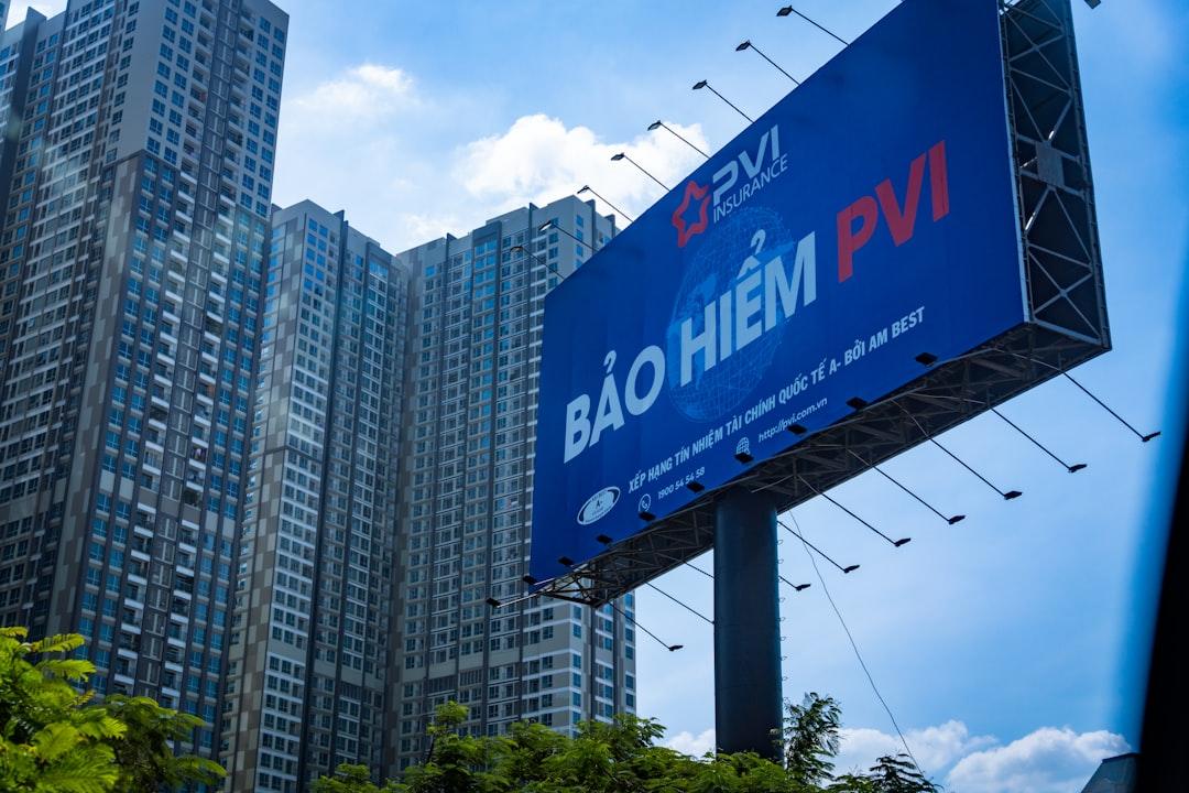 a large blue sign hanging from the side of a tall building
